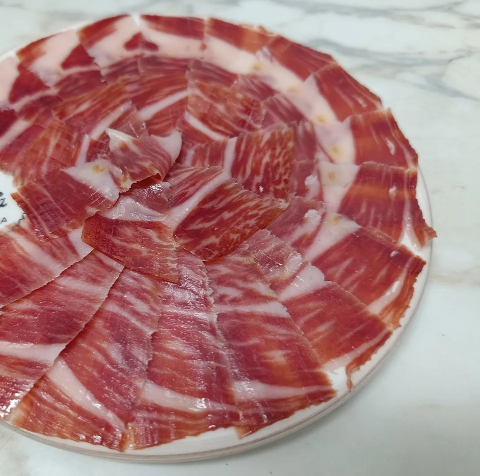 Plato de jamón ibérico cortado a cuchillo y colocado en forma de rosa